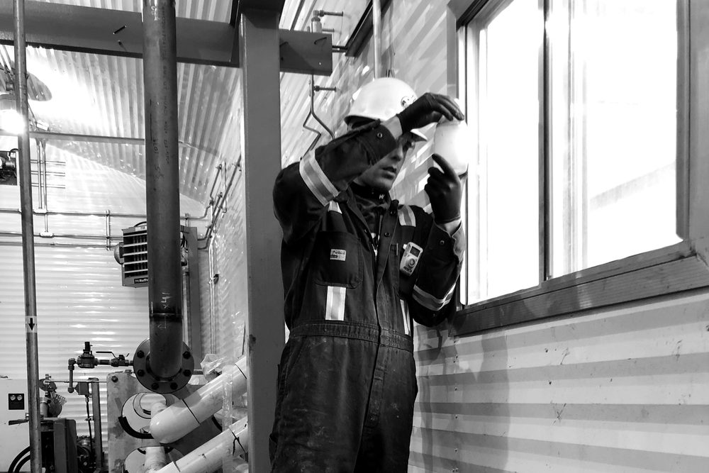 Field operator collecting a water sample for independent chemical testing